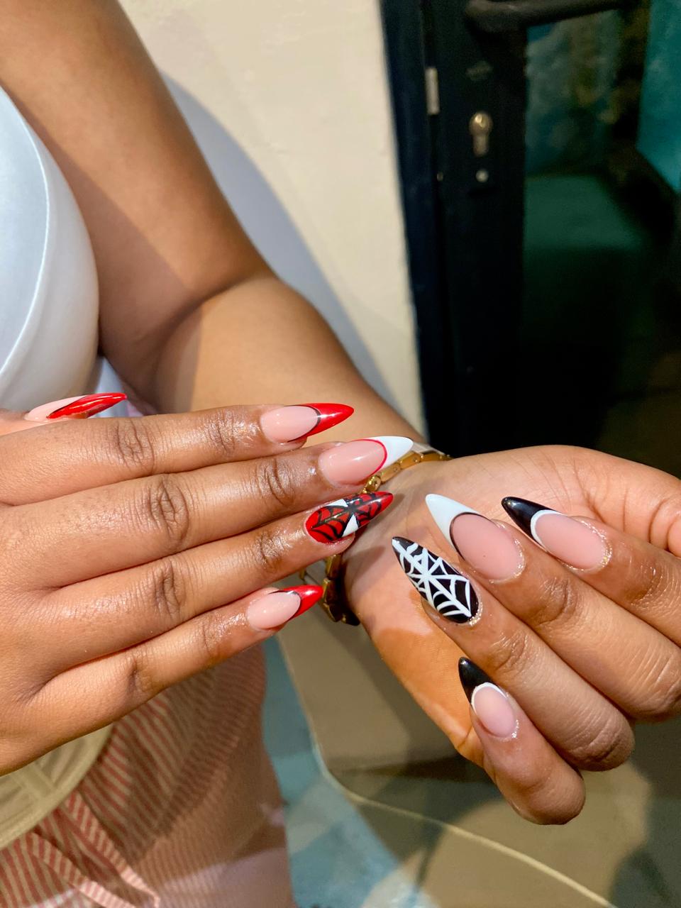 Spider-web nail art with red and black French tips by Standard Beauty Midrand